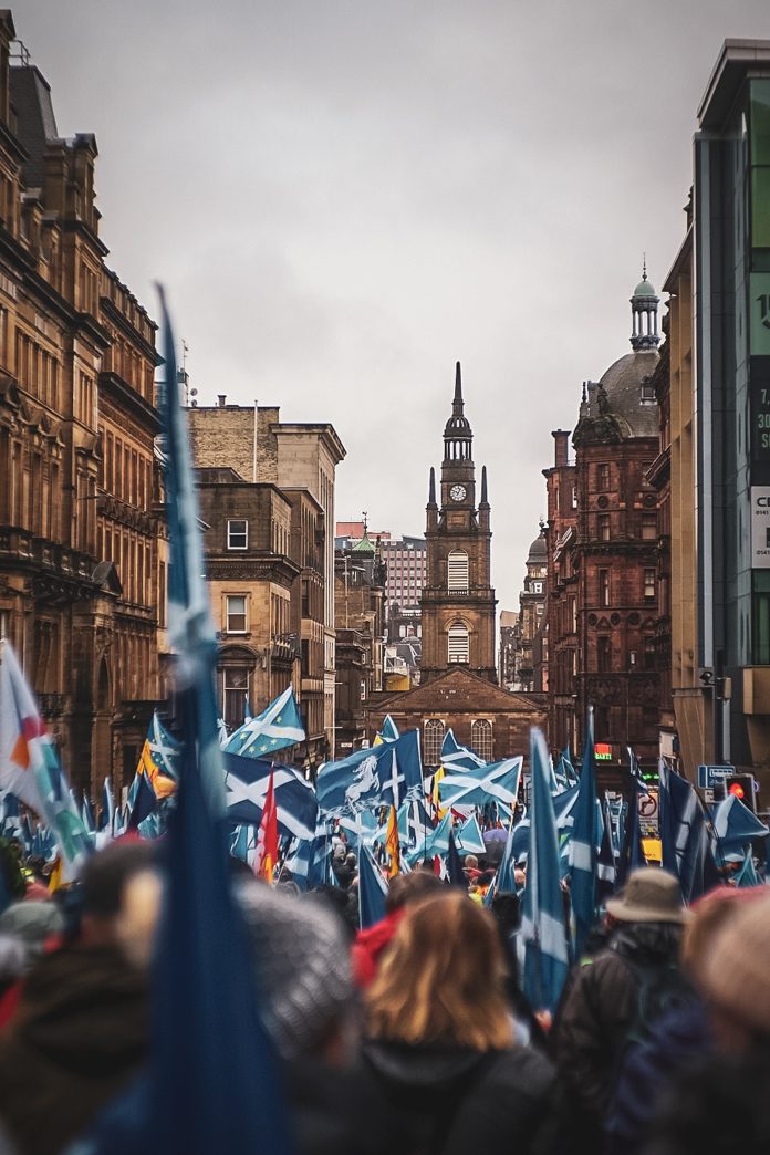 People in a street holding the Scottish flag