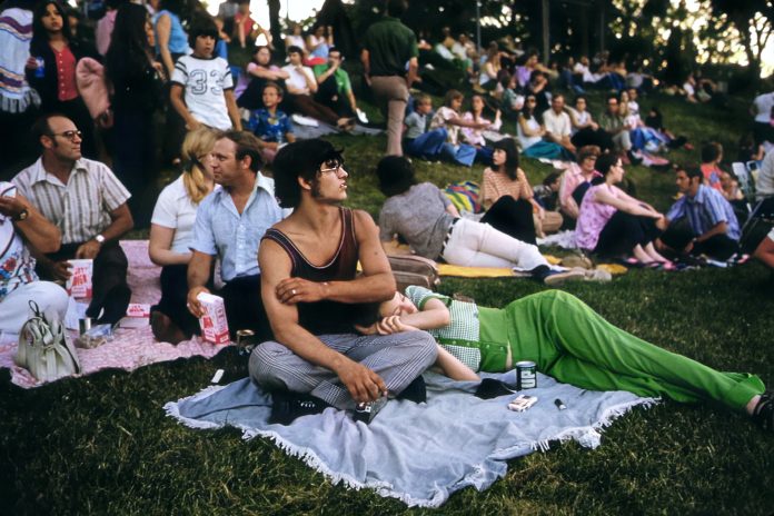 A group of people in the 70s sitting in a field