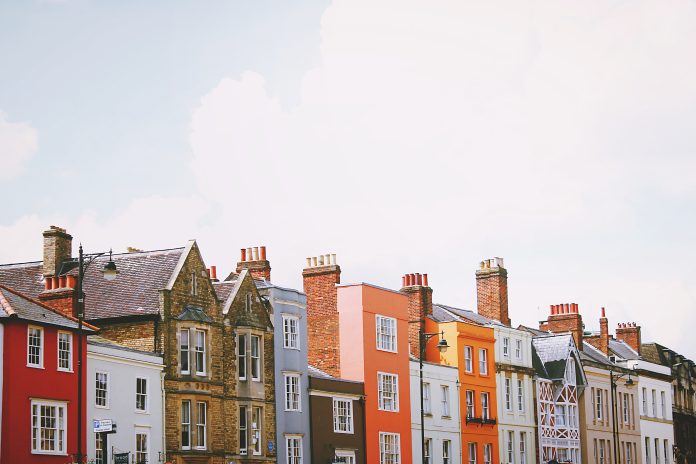 Assorted colour concrete houses under white clouds in the daytime